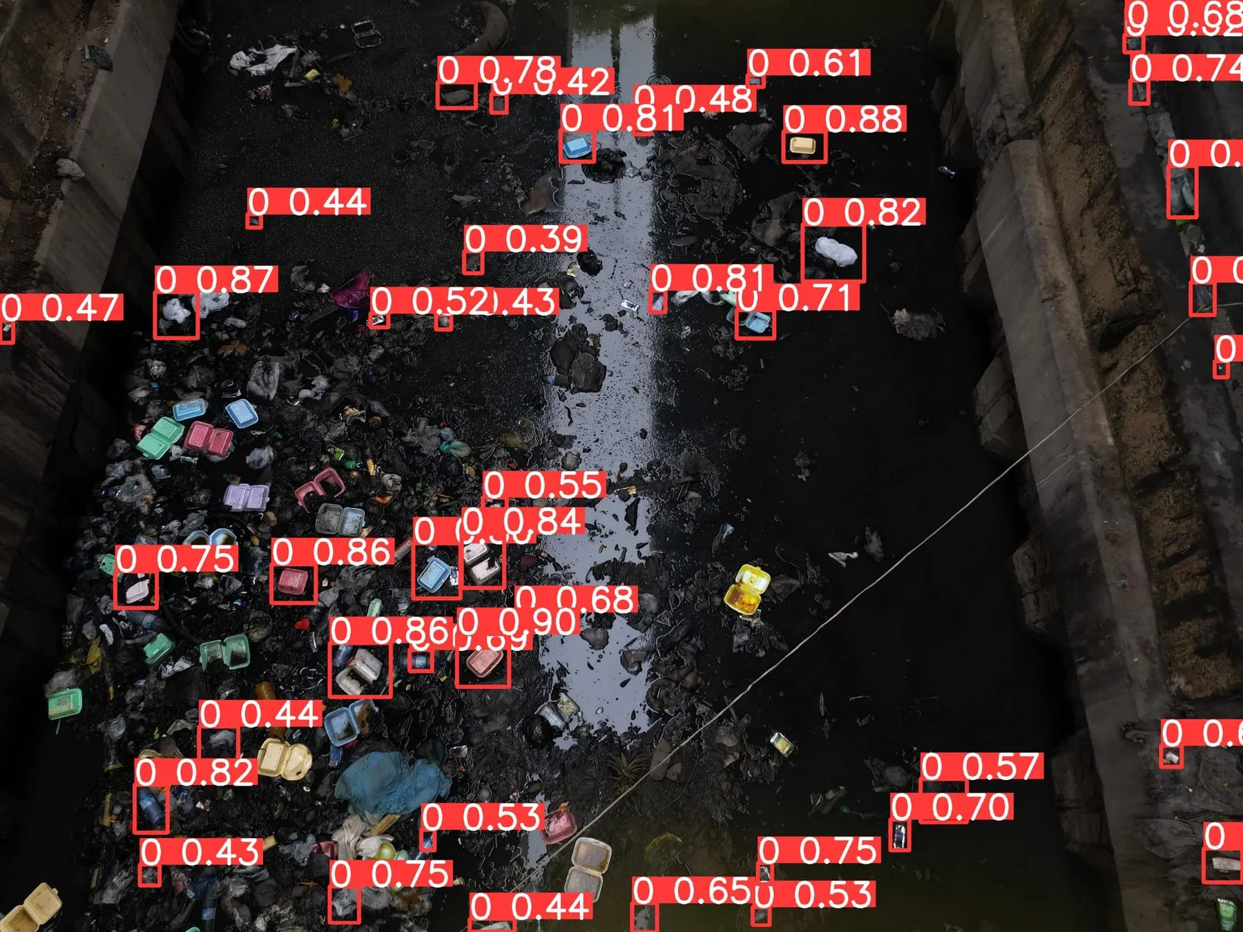 Top-down view of a debris-choked channel with dozens of plastic items detected.